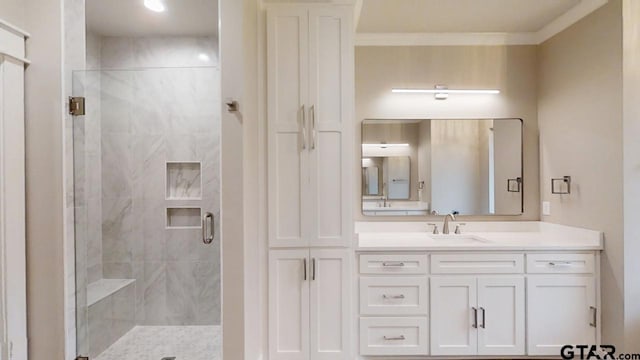 bathroom with vanity, crown molding, and walk in shower