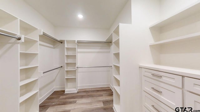 walk in closet with light hardwood / wood-style flooring