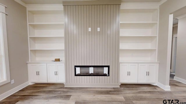 interior space with built in shelves, light wood-type flooring, and a multi sided fireplace