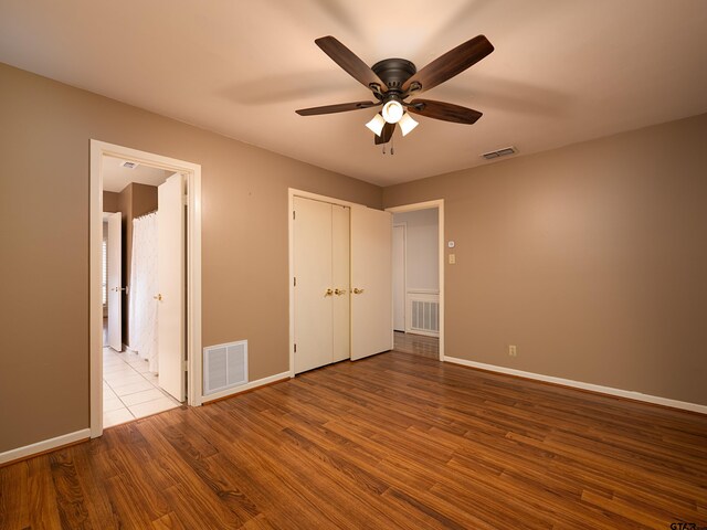 unfurnished bedroom with ceiling fan and light wood-type flooring