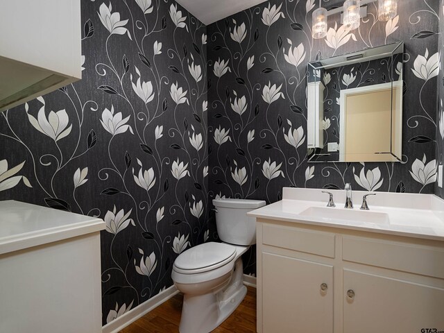 bathroom featuring wood-type flooring, vanity, and toilet