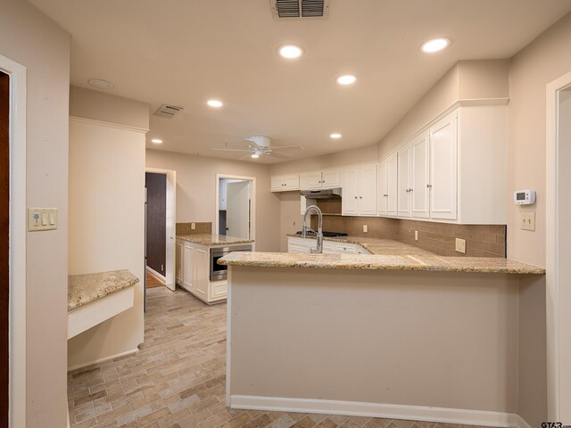 kitchen featuring tasteful backsplash, kitchen peninsula, white cabinetry, and ceiling fan