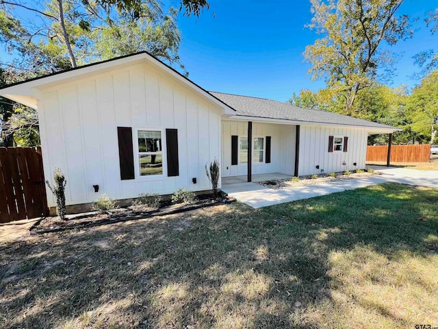 view of front of home featuring a front yard and a patio