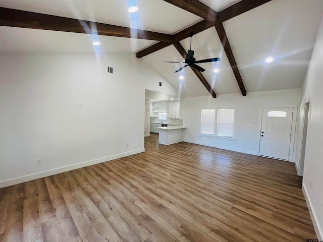 unfurnished living room featuring light hardwood / wood-style floors, beamed ceiling, and ceiling fan