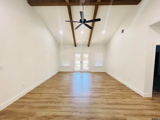 unfurnished living room with french doors, light hardwood / wood-style floors, beam ceiling, and high vaulted ceiling