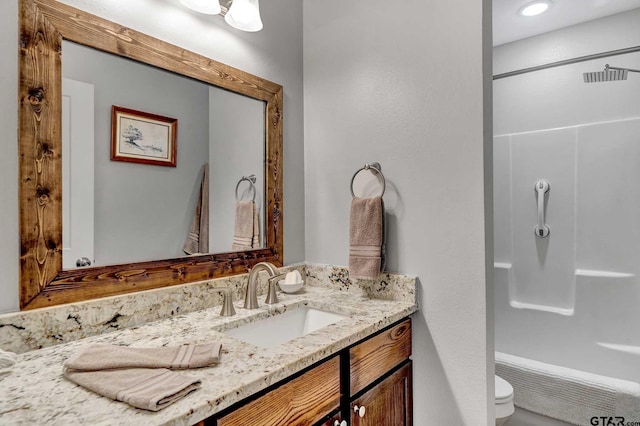 bathroom with vanity, a shower, and toilet