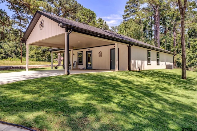 view of front of home with a carport, central AC unit, and a front lawn