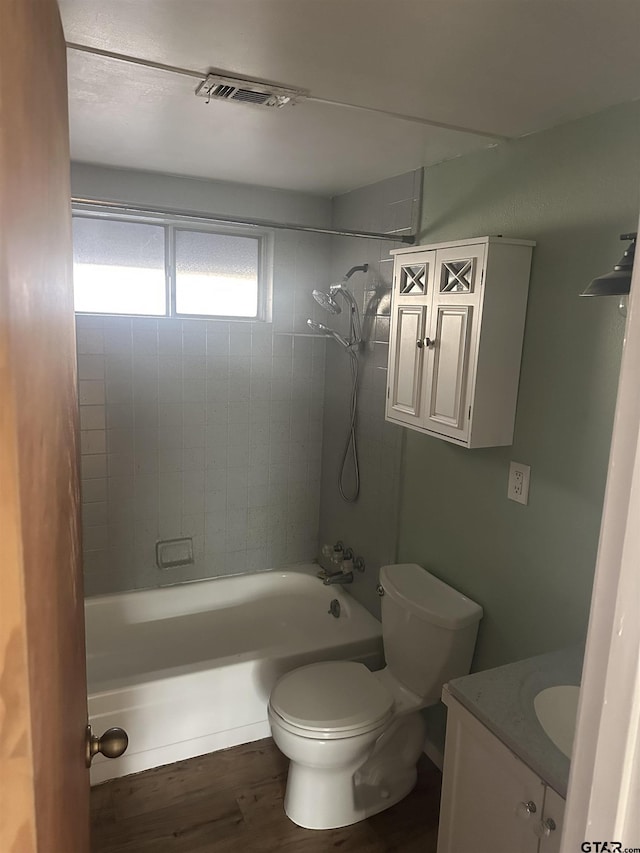 full bathroom with hardwood / wood-style flooring, vanity, toilet, and tiled shower / bath