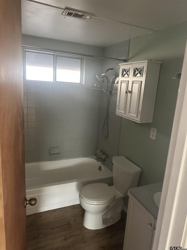 full bathroom featuring hardwood / wood-style floors, vanity, toilet, and tiled shower / bath