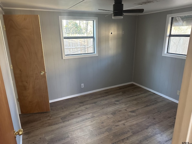 empty room featuring ceiling fan, dark hardwood / wood-style flooring, and ornamental molding