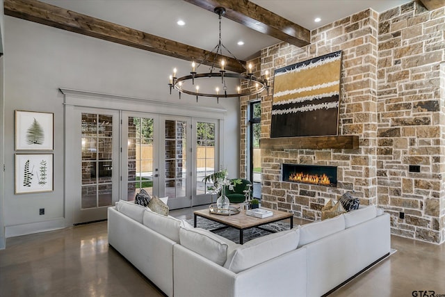 living room featuring concrete floors, french doors, beamed ceiling, and a fireplace