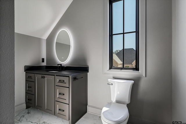 bathroom featuring vaulted ceiling, toilet, and vanity