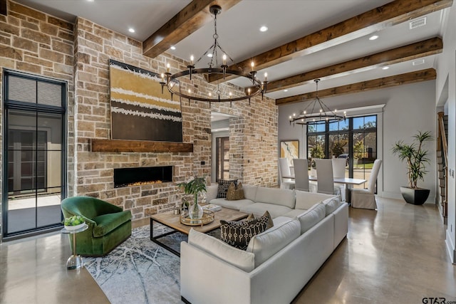 living room with a fireplace, beamed ceiling, a notable chandelier, and concrete flooring