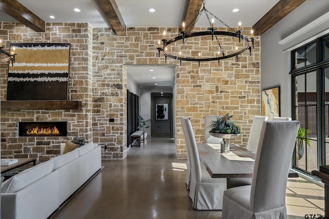 dining area featuring a fireplace and beamed ceiling