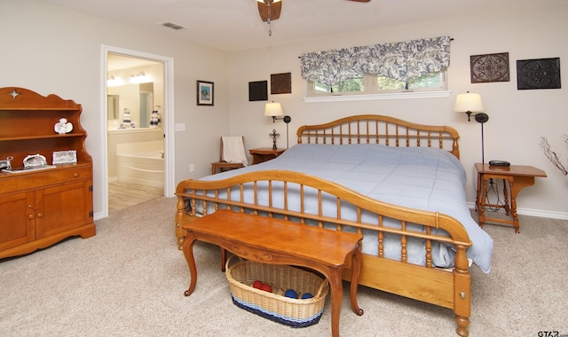 carpeted bedroom with ensuite bathroom and ceiling fan