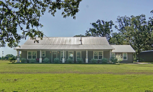 view of front of house with metal roof and a front yard