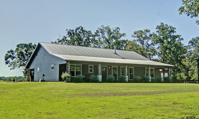 view of front of home with metal roof and a front lawn