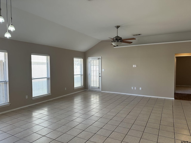 empty room featuring ceiling fan, a healthy amount of sunlight, lofted ceiling, and light tile patterned flooring