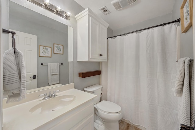 bathroom featuring vanity, wood-type flooring, and toilet