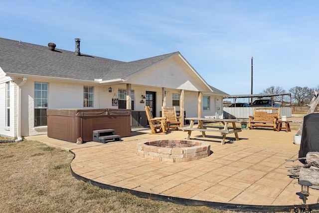 view of patio / terrace with an outdoor fire pit, a hot tub, and a pergola