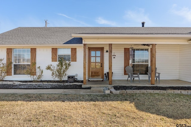 ranch-style home with ceiling fan, a porch, and a front lawn