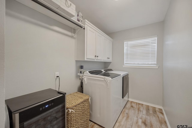 laundry area featuring light hardwood / wood-style flooring, cabinets, and washing machine and clothes dryer