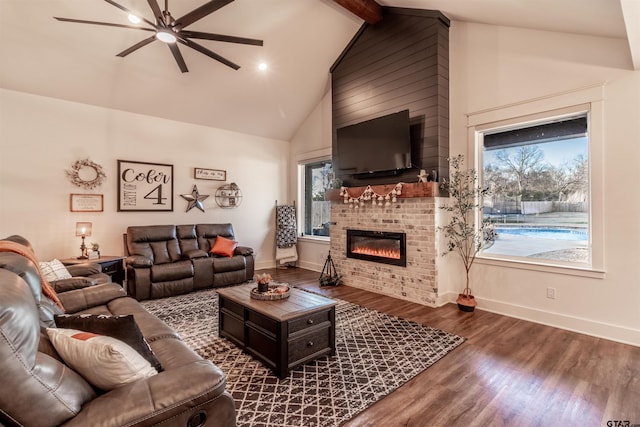 living room featuring dark hardwood / wood-style flooring, a fireplace, plenty of natural light, and lofted ceiling with beams