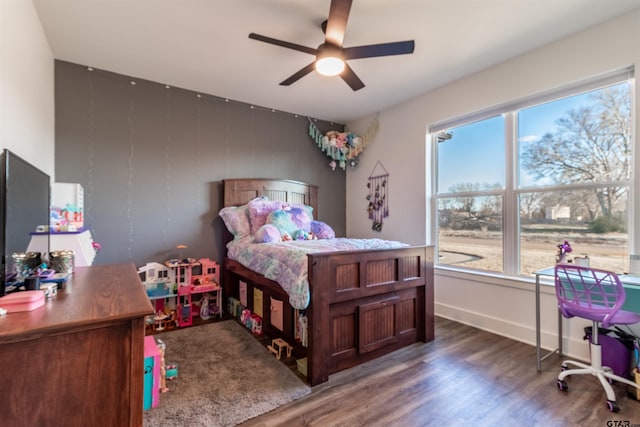 bedroom featuring ceiling fan, baseboards, and wood finished floors