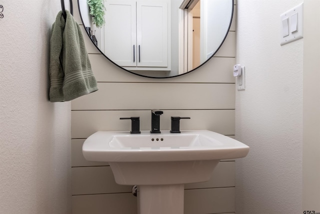 bathroom with a textured wall and a sink