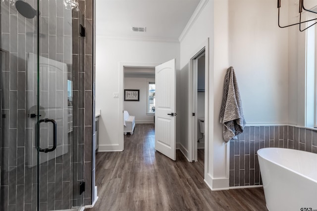 full bathroom featuring crown molding, hardwood / wood-style flooring, vanity, shower with separate bathtub, and toilet