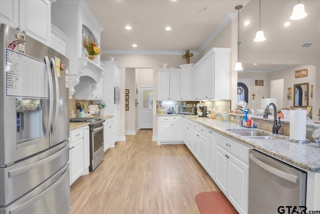 kitchen with white cabinets, stainless steel appliances, hanging light fixtures, and sink