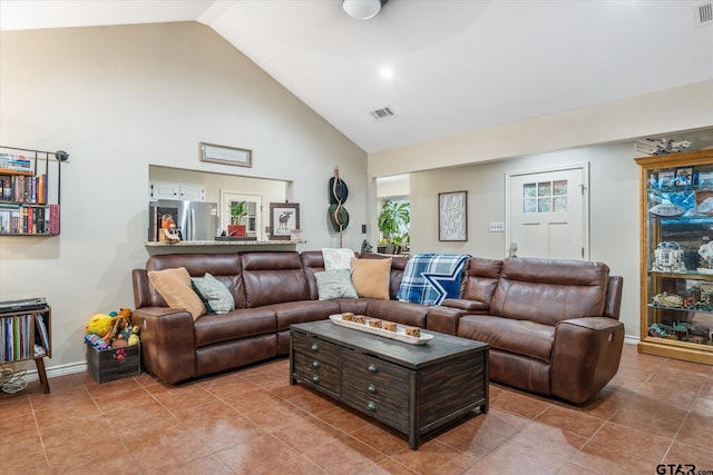 living room with tile patterned floors and high vaulted ceiling