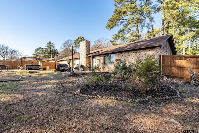 back of property with a jacuzzi