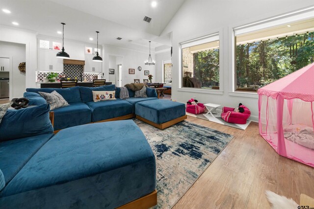 living room with lofted ceiling, visible vents, wood finished floors, and recessed lighting