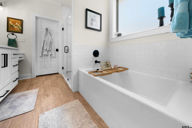 full bath with a garden tub, a shower stall, and wood finished floors