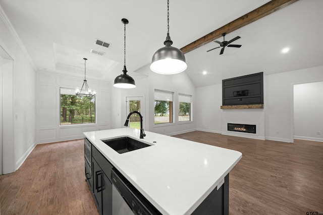 21488 Forest Pl, Flint, TX 75762 - kitchen with stainless steel dishwasher, light countertops, a glass covered fireplace, and wood finished floors