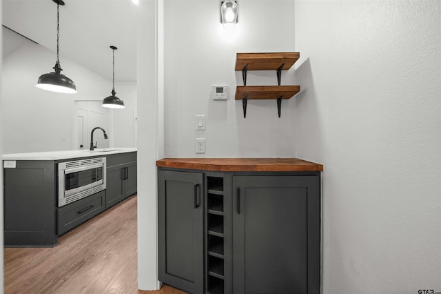 21488 Forest Pl, Flint, TX 75762 - bar featuring stainless steel microwave, light wood-type flooring, and pendant lighting