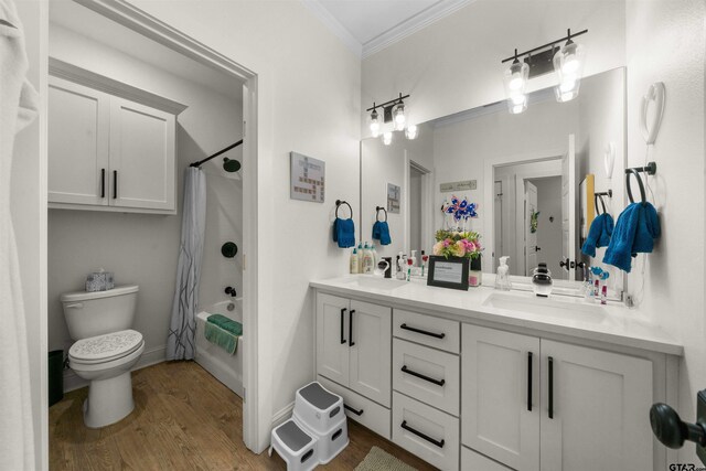 bathroom featuring toilet, wood finished floors, ornamental molding, double vanity, and shower / bath combo with shower curtain