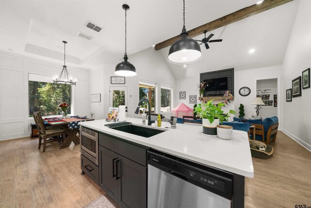 kitchen featuring stainless steel appliances, hanging light fixtures, a sink, and visible vents