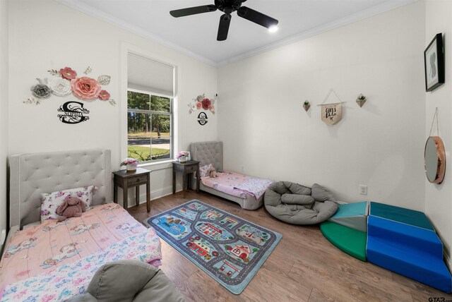 bedroom with a ceiling fan, crown molding, and wood finished floors