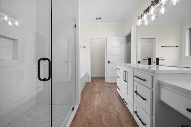 21488 Forest Pl, Flint, TX 75762 - bathroom with vanity, a stall shower, ornamental molding, wood finished floors, and a garden tub