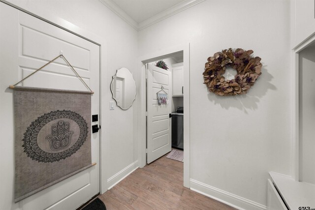 corridor featuring crown molding, light wood-style flooring, and baseboards