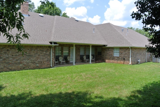 rear view of house with a patio area and a yard