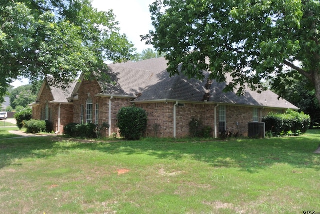 view of front of house featuring a front yard and central AC