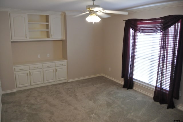 interior space featuring ornamental molding, light carpet, and ceiling fan