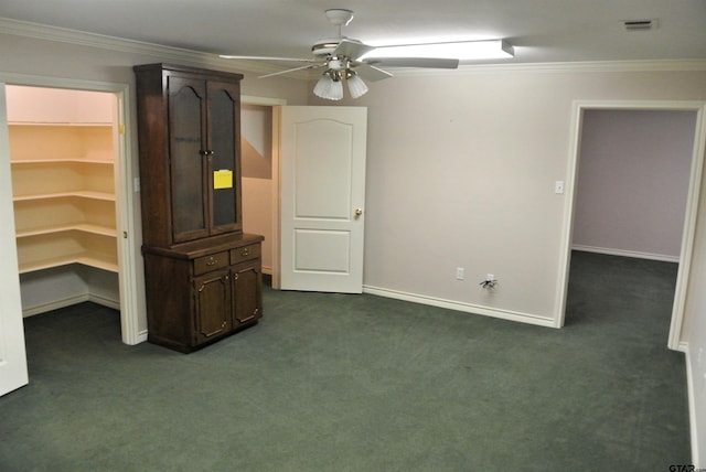 interior space with ceiling fan, dark carpet, and crown molding