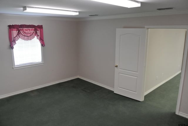 unfurnished room with ornamental molding and dark carpet