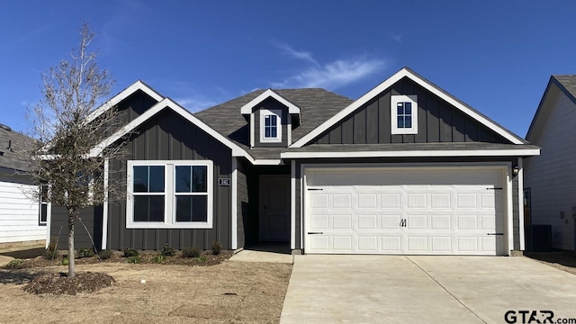 view of front of property with board and batten siding, driveway, and an attached garage