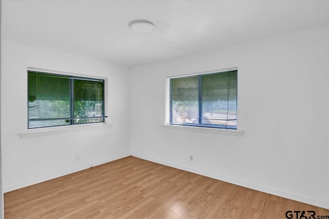 unfurnished room featuring light hardwood / wood-style floors and plenty of natural light