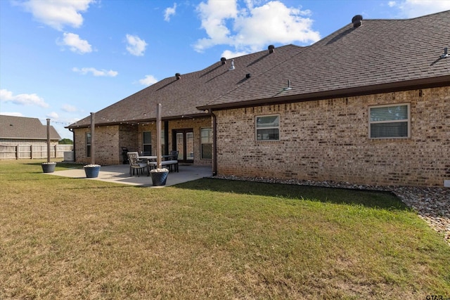 back of property featuring a patio area and a lawn